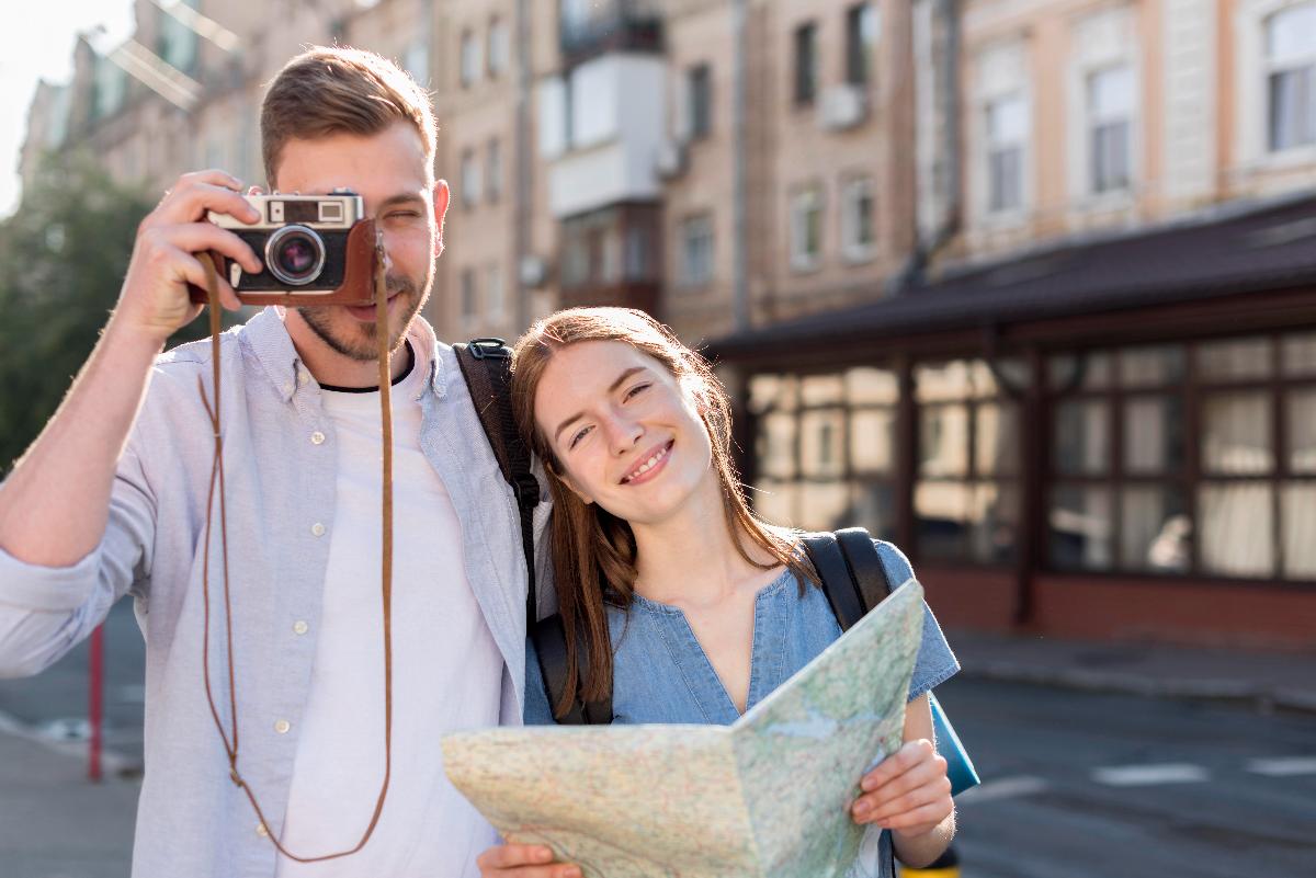 tourist couple posing outdoors with camera and map