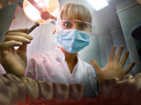 Young female doctor looking inside patients mouth